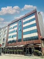 Un hotel con fachada moderna, amplias ventanas y un cartel que dice "HOTEL ELITA".