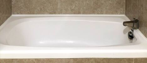 Un baño con bañera, toallero y barandilla.