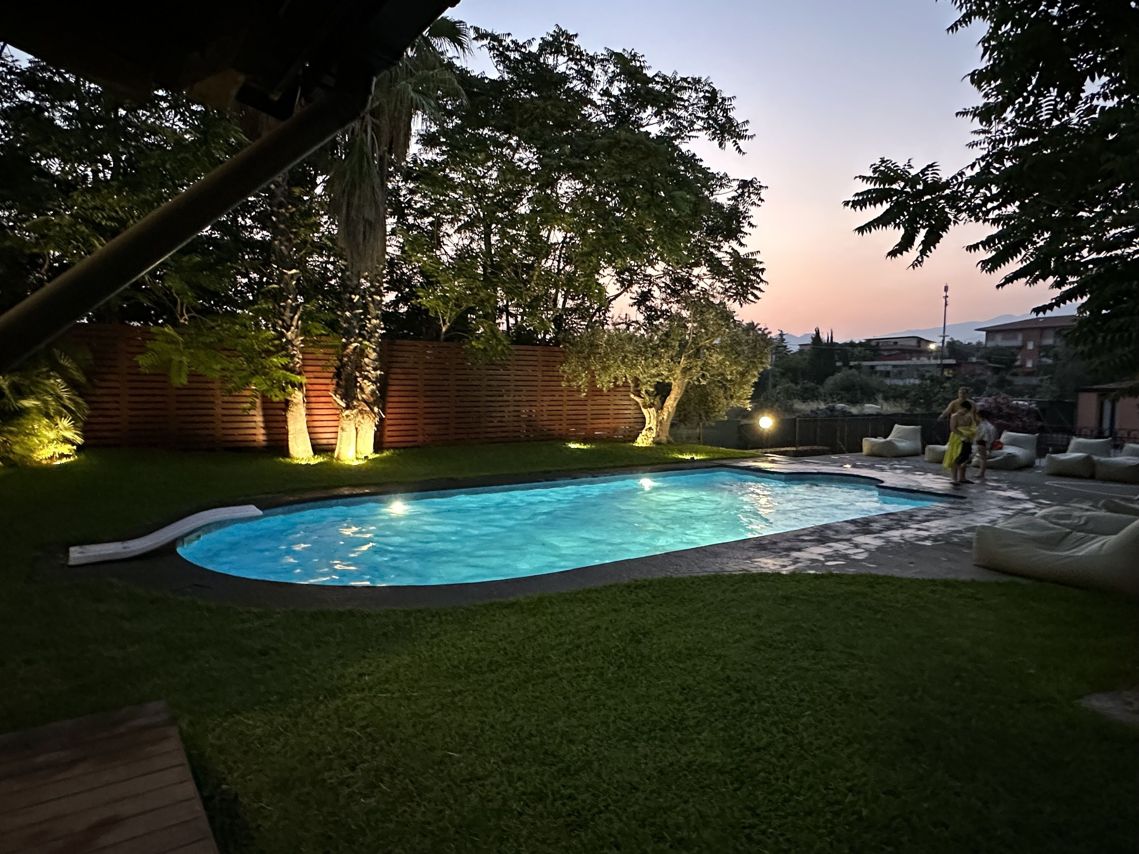 Une piscine dotée d’une terrasse en bois et d’une zone herbeuse.