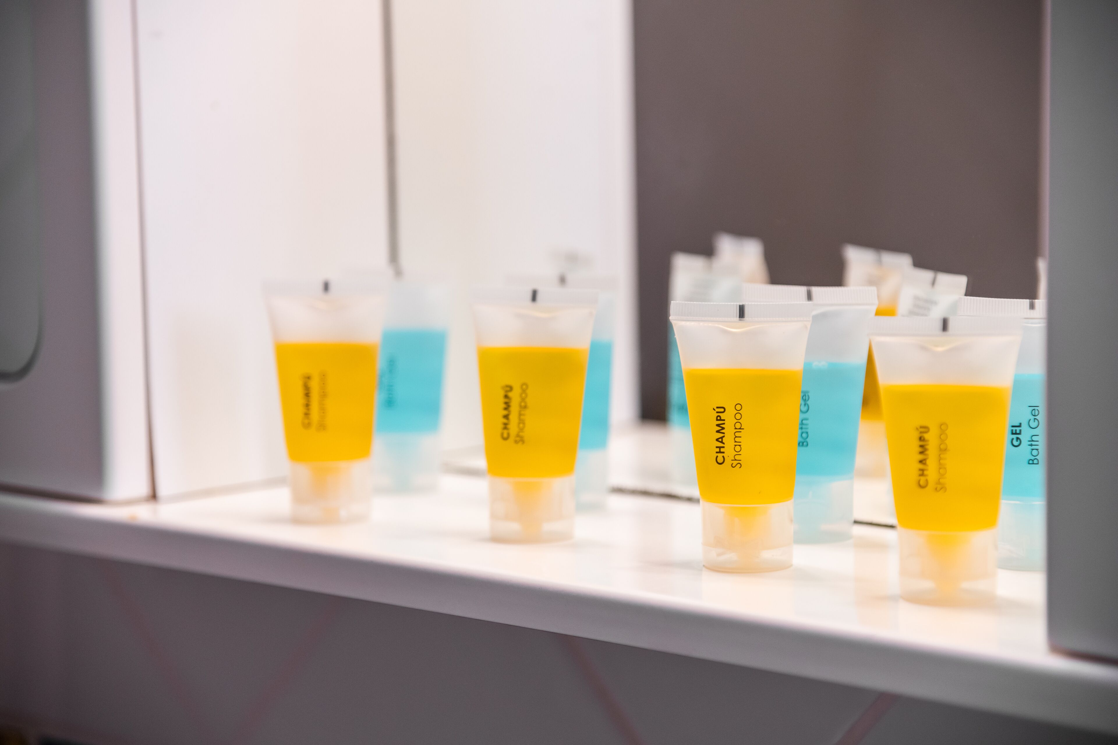 Una exhibición de varios productos para el cuidado del cabello en recipientes transparentes sobre una estantería.