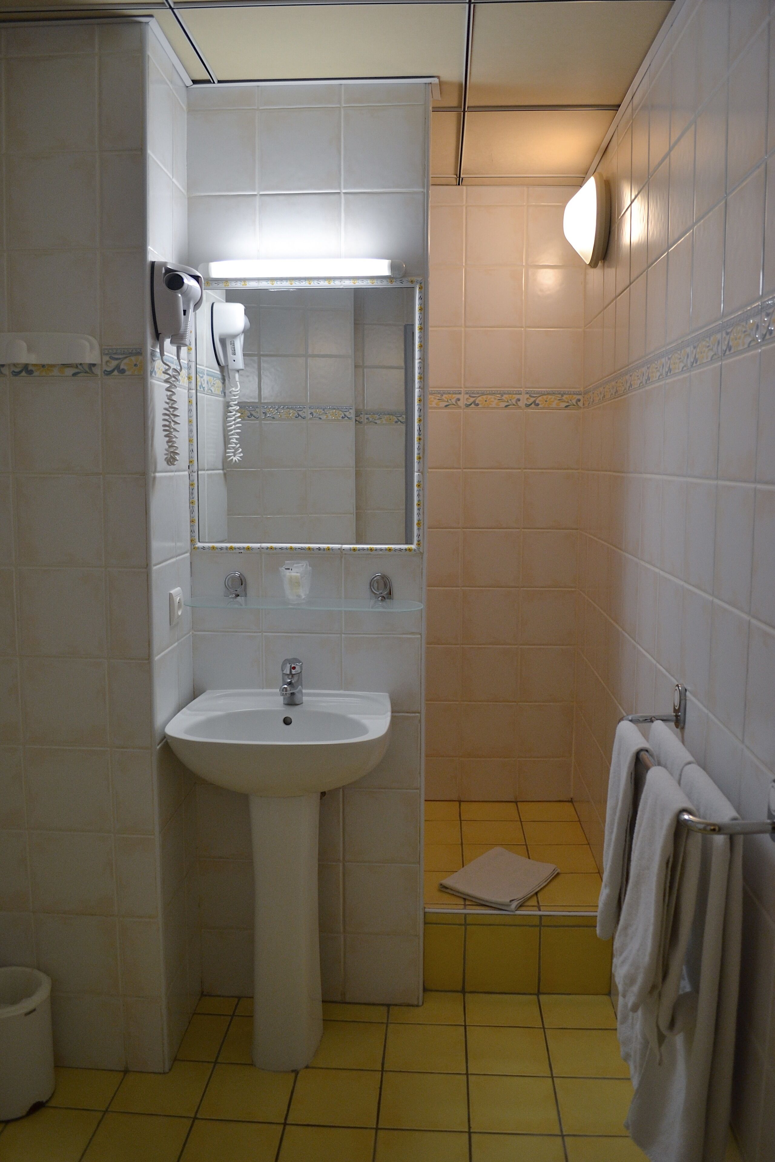 Ein Badezimmer mit Waschbecken, Spiegel und Handtuchhalter.