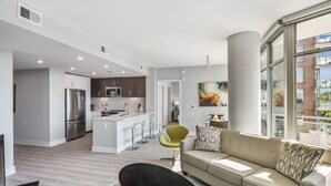 Een modern appartement met keuken, woonruimte en grote ramen.