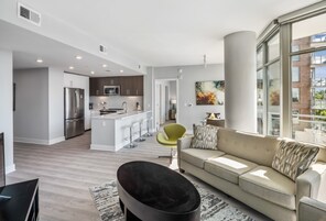 Um apartamento moderno com cozinha, sala de estar e janelas amplas.