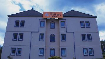 A multi-story hotel building with a sign reading "HOTEL PREMIERE CLASSE".
