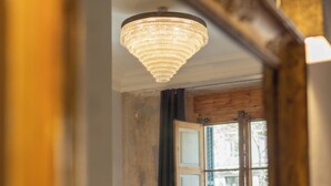 Camera da letto con un letto grande, un lampadario e vista dalla finestra.