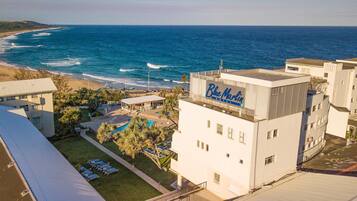 A hotel with a pool, beach view, and a sign for 'Blae Marlin Hotel.'