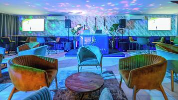 A lounge area with comfortable seating, a stage, and a DJ booth.