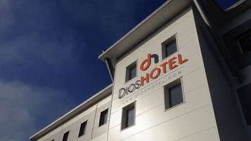 A modern hotel building with a sign reading "Dioshotel".