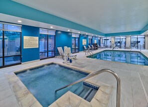 A hotel swimming pool with clear water, lounge chairs, and safety signs. - Hampton Inn Omaha Midtown-Aksarben Area (Omaha)
