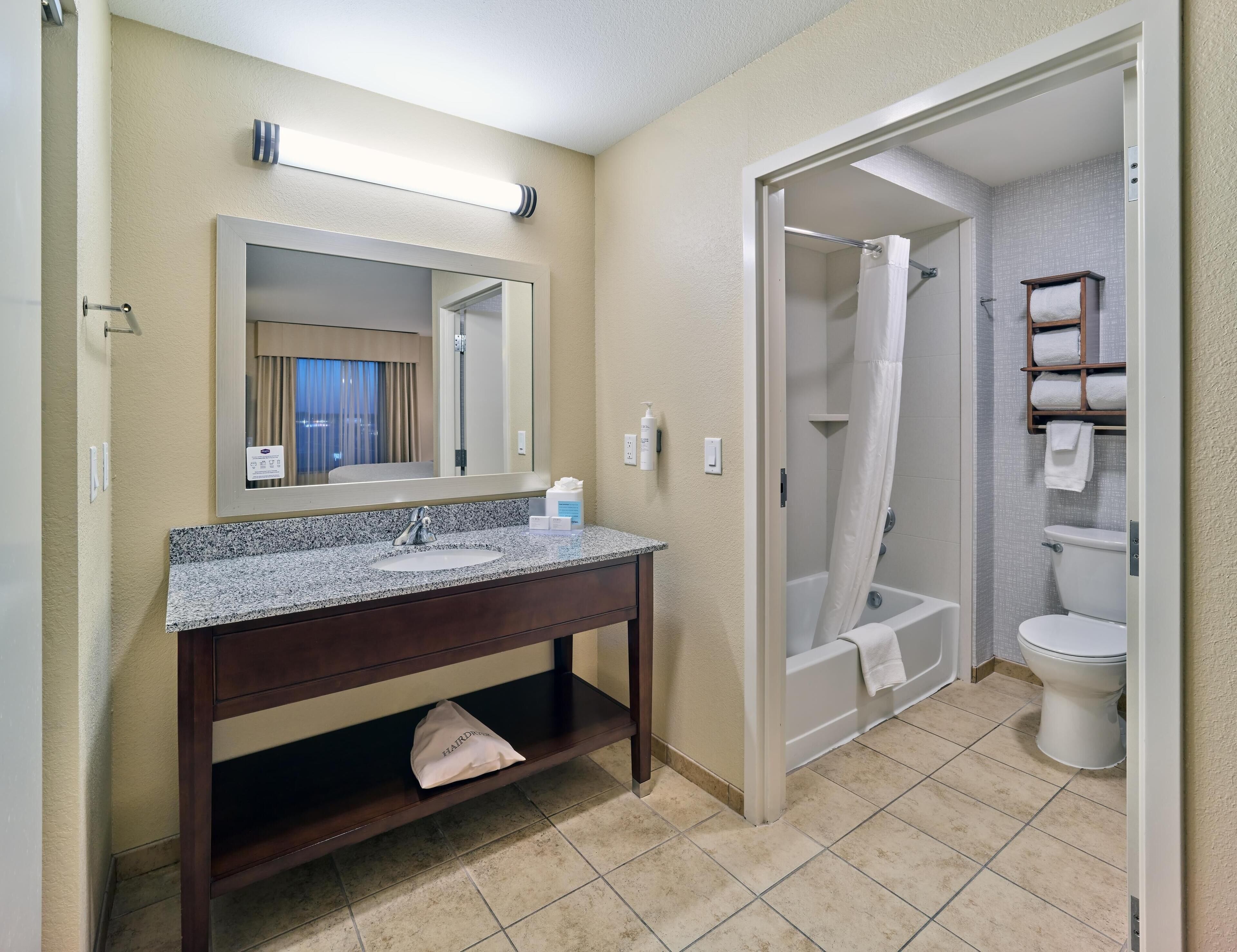 Un bagno con lavandino, specchio, doccia e water.