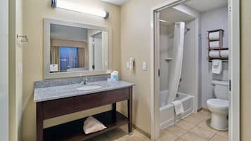 Un bagno con lavandino, specchio, doccia e water.