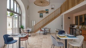 A modern dining area with a staircase, dining tables, and chairs. - Clos Marcamps (Prignac-et-Marcamps)
