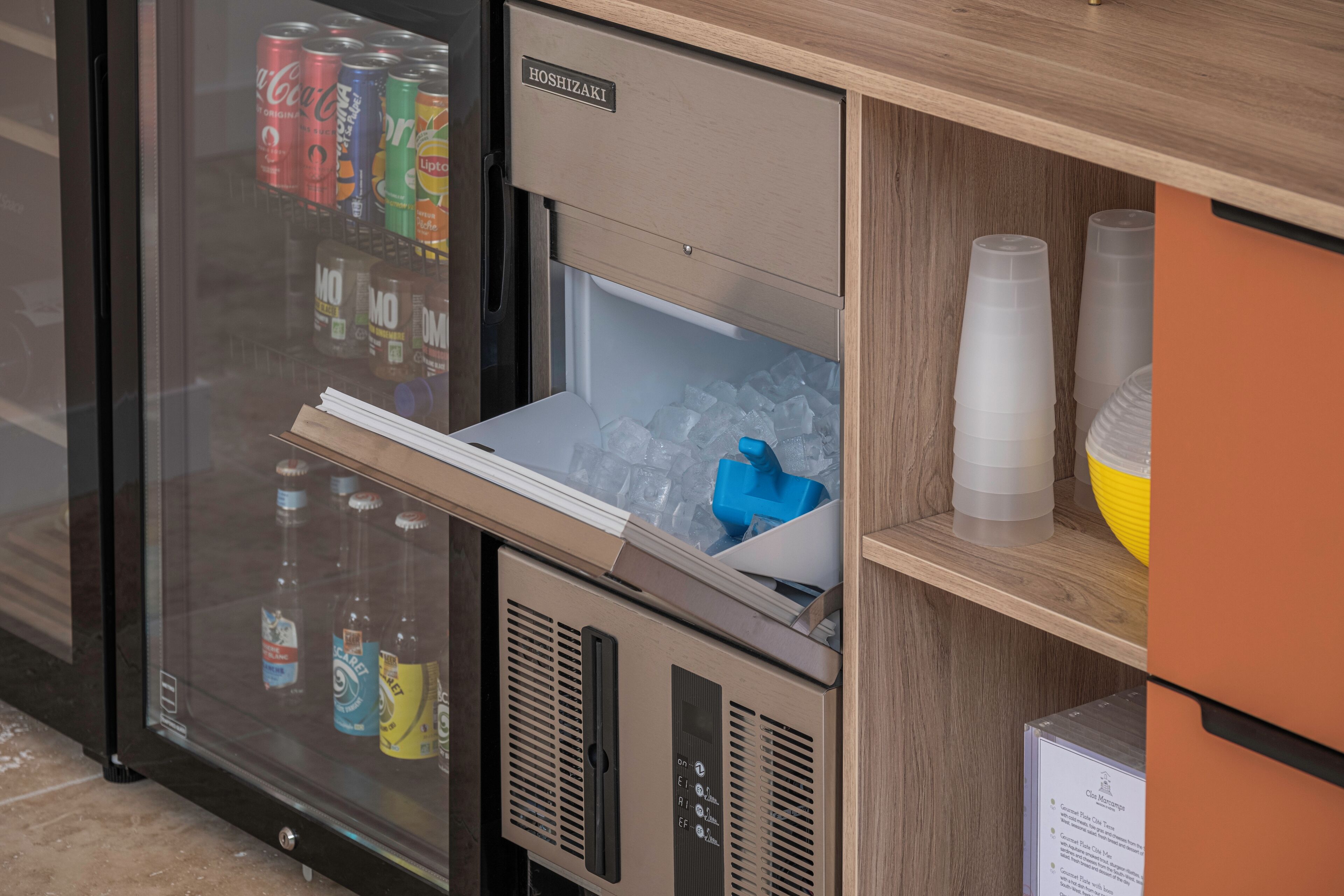 Un mini-bar équipé d’un réfrigérateur contenant des boissons et d’un petit congélateur.