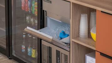 Un mini-bar équipé d’un réfrigérateur contenant des boissons et d’un petit congélateur.