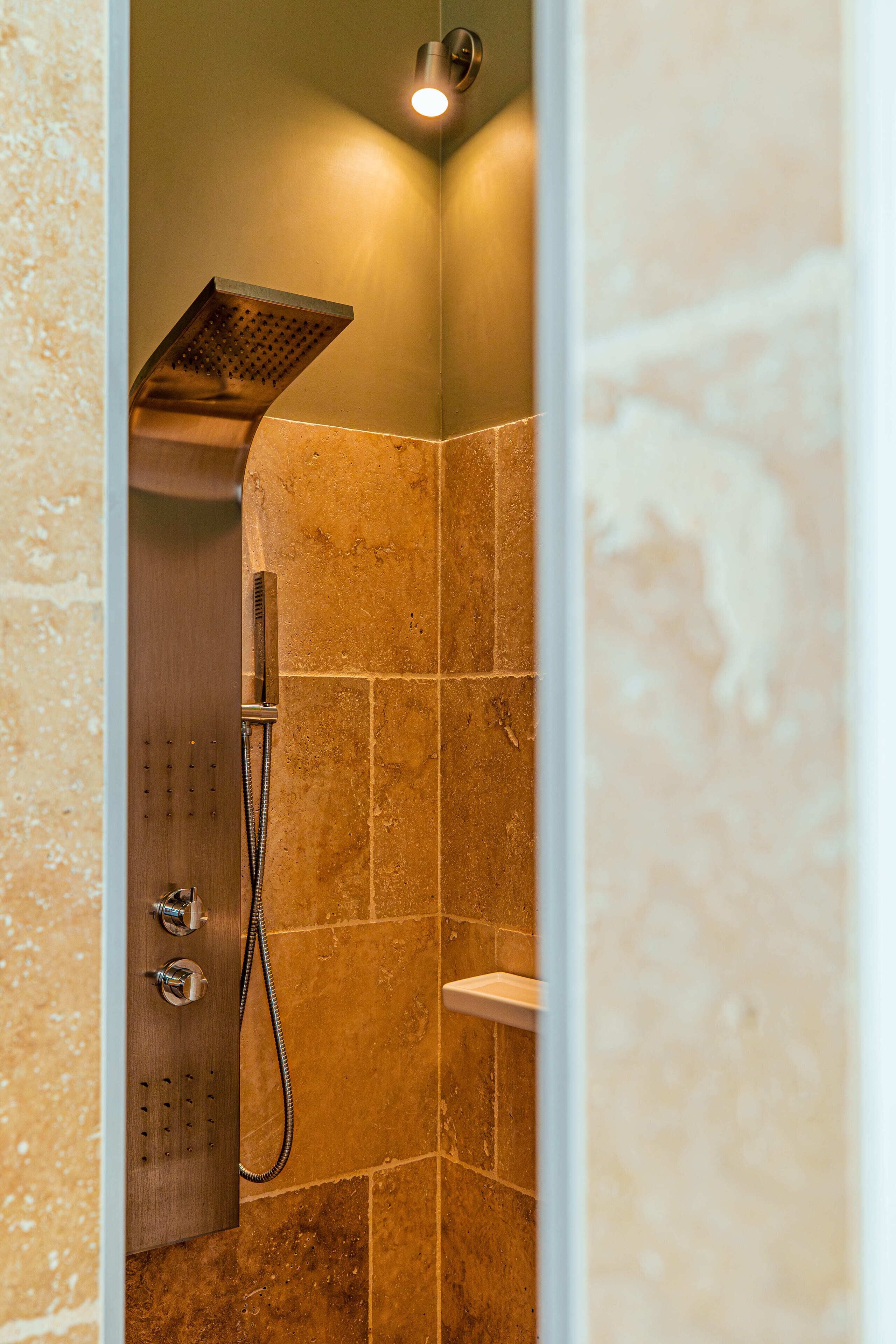 Eine Dusche mit Handbrause und einer fest installierten Bedienkonsole.