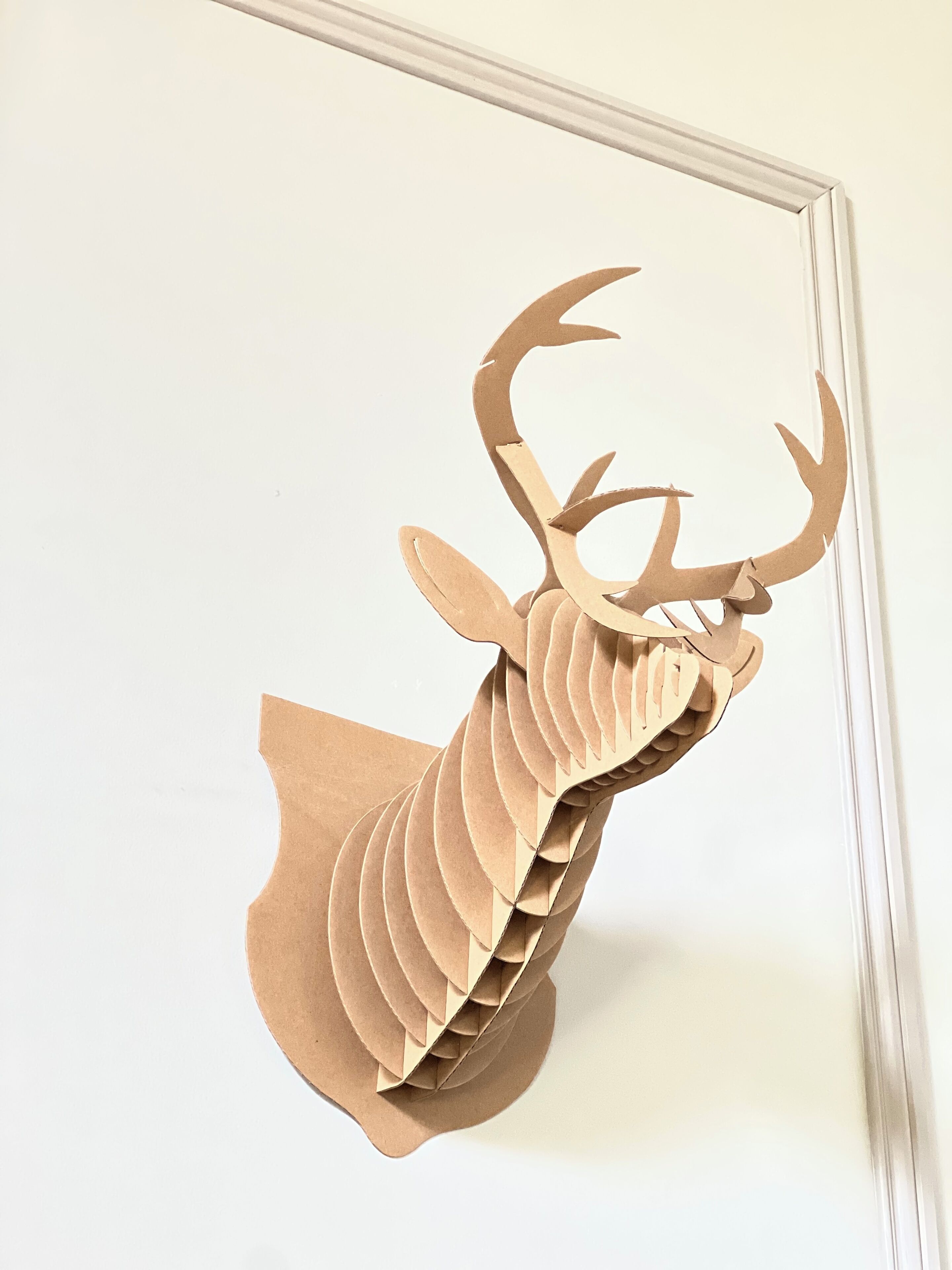 A paper deer mounted on a wall.