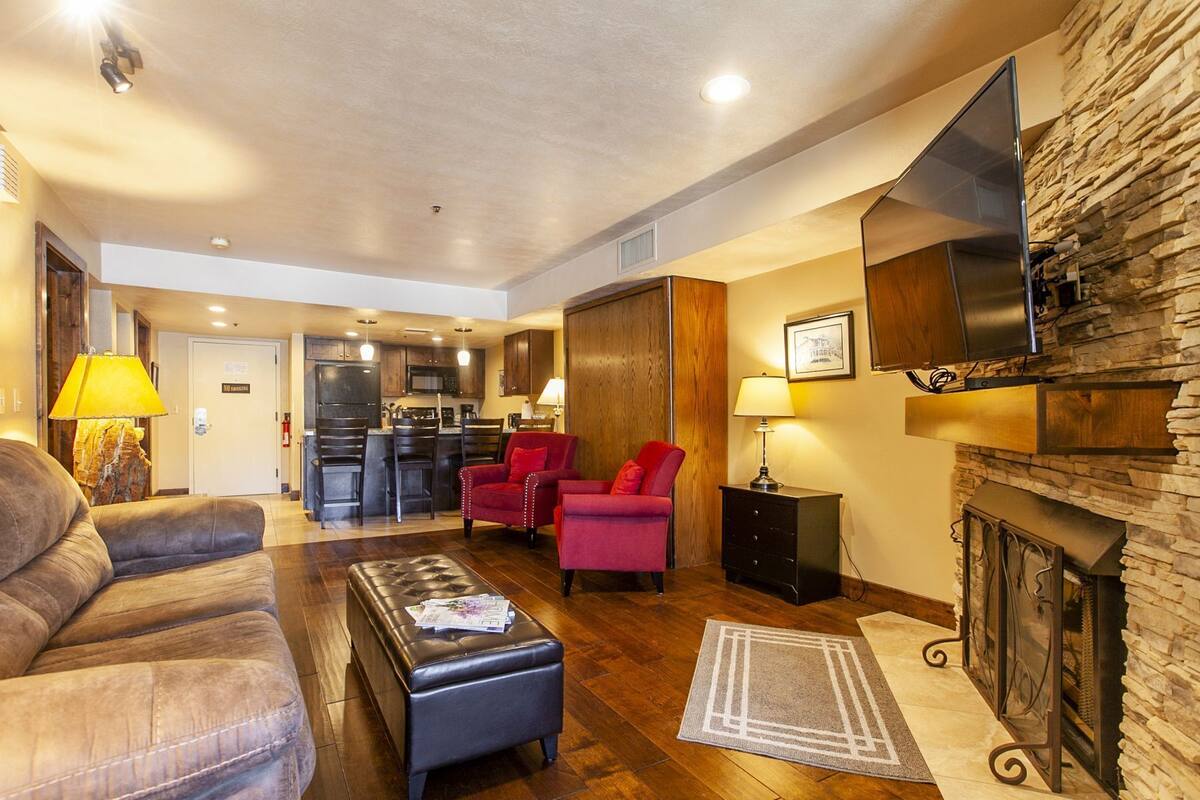 A spacious living room with a fireplace, a kitchen area, and a dining space.