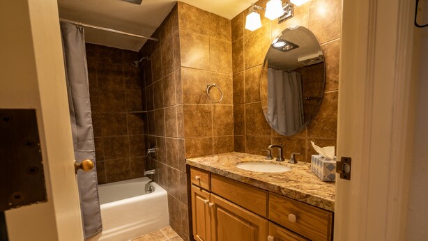 A bathroom with a bathtub, a sink, and a vanity with drawers. - Lodge at Mountain Village by Park City Vacations (Park City)