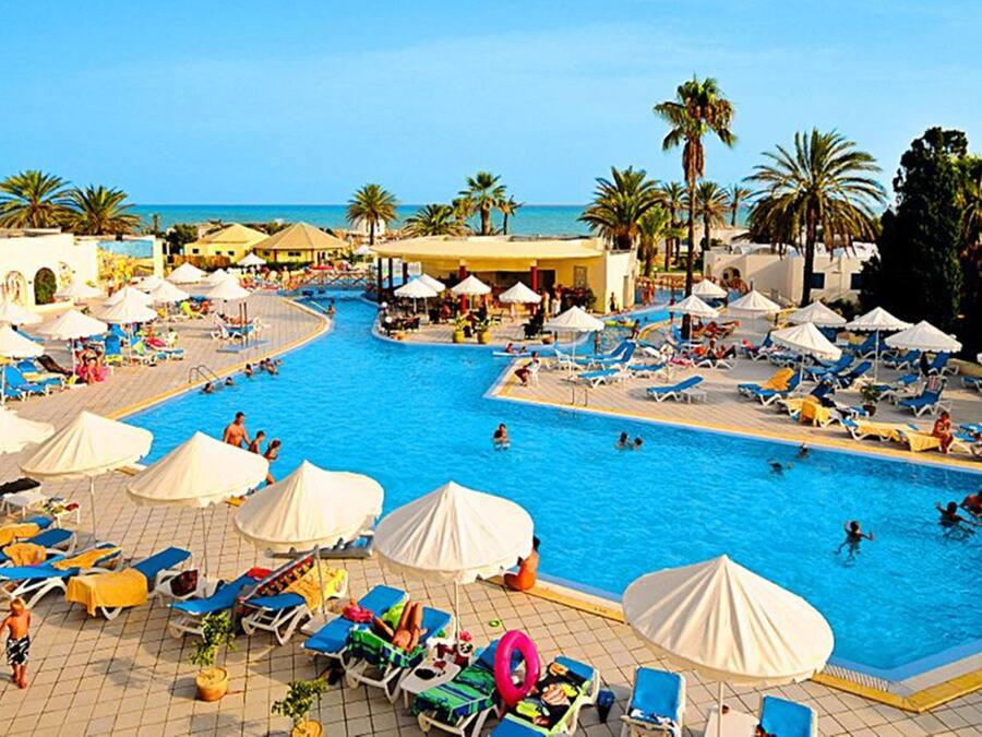 Una piscina cubierta, una piscina al aire libre, sombrillas, tumbonas