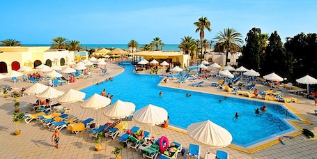 Indoor pool, outdoor pool, pool umbrellas, pool loungers. Royal Lido Resort & Spa