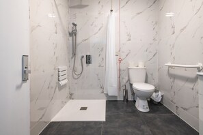 A modern bathroom with a walk-in shower, a toilet, and a handrail. - Peterborough by Verve (Peterborough)
