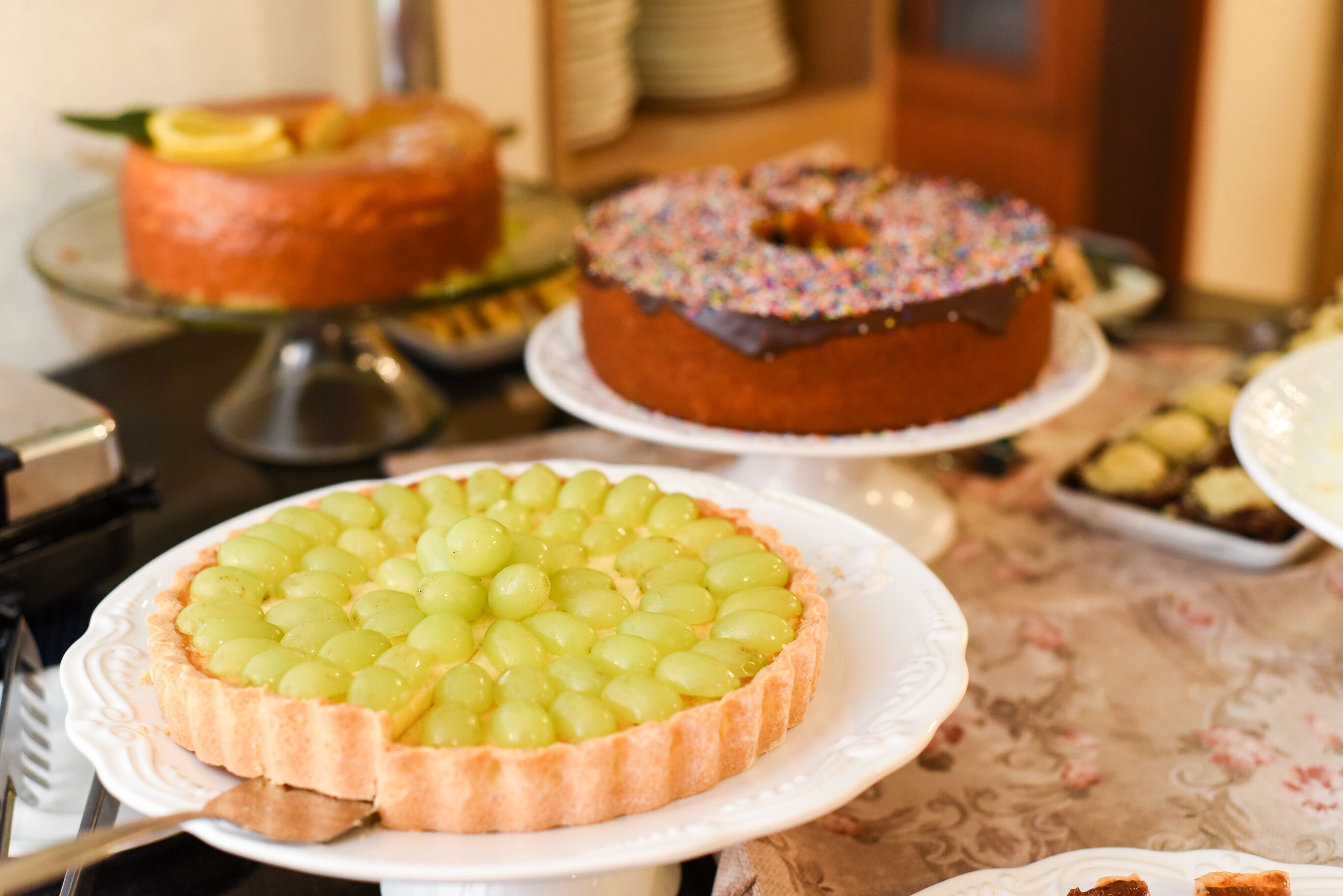 A table with various cakes and desserts.