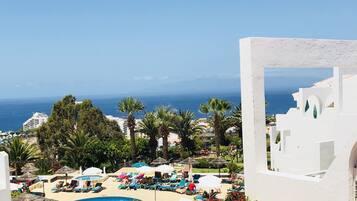 Una piscina al aire libre, sillones reclinables de piscina