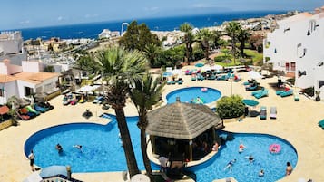 Una piscina al aire libre, sillones reclinables de piscina