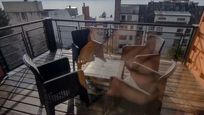 En takterrass med utemöbler och utsikt över stadsbilden.