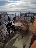 Terraza en la azotea con mobiliario exterior y vistas a la ciudad.