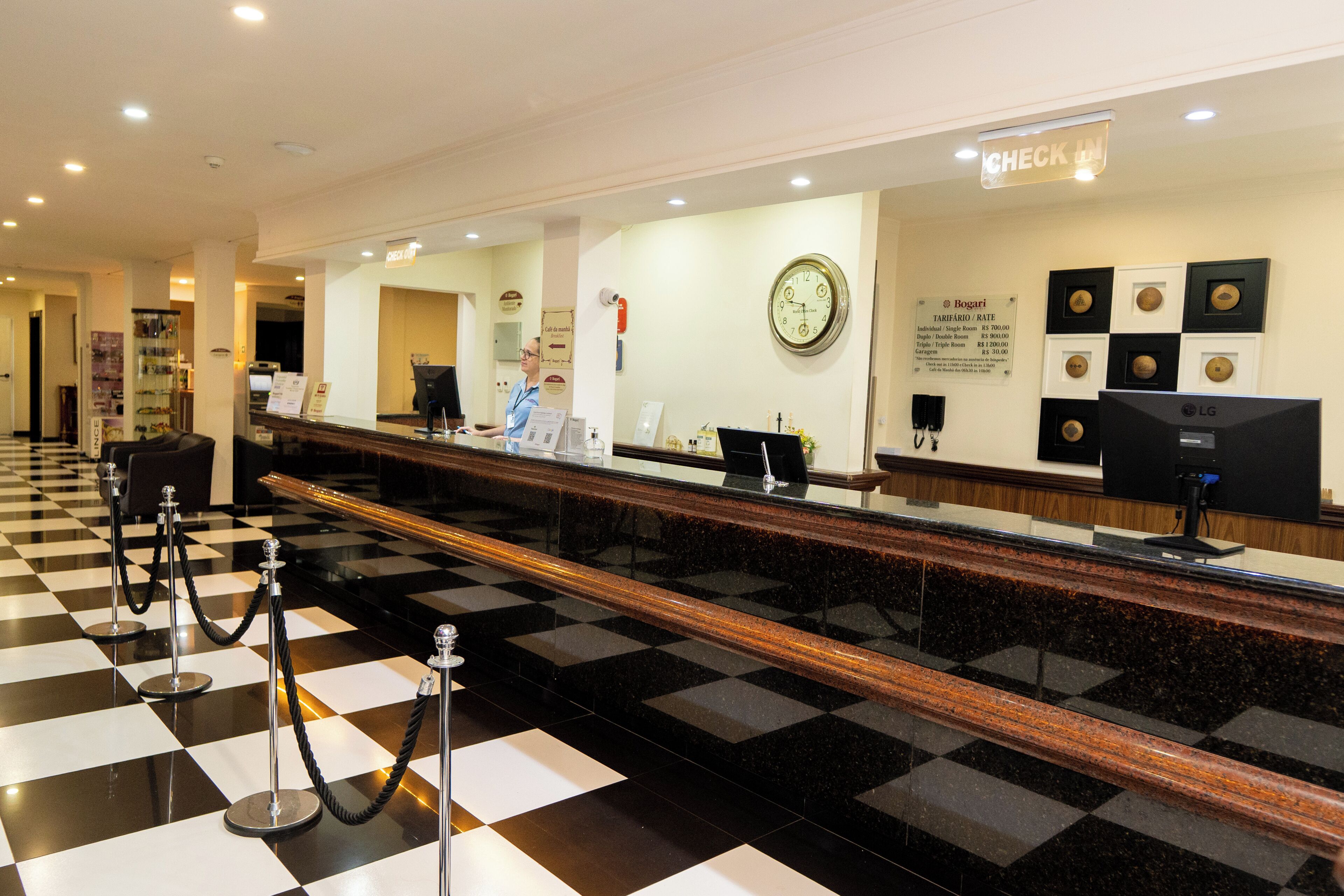 A hotel reception area with a check-in counter, a clock, and a sign indicating the check-in location.