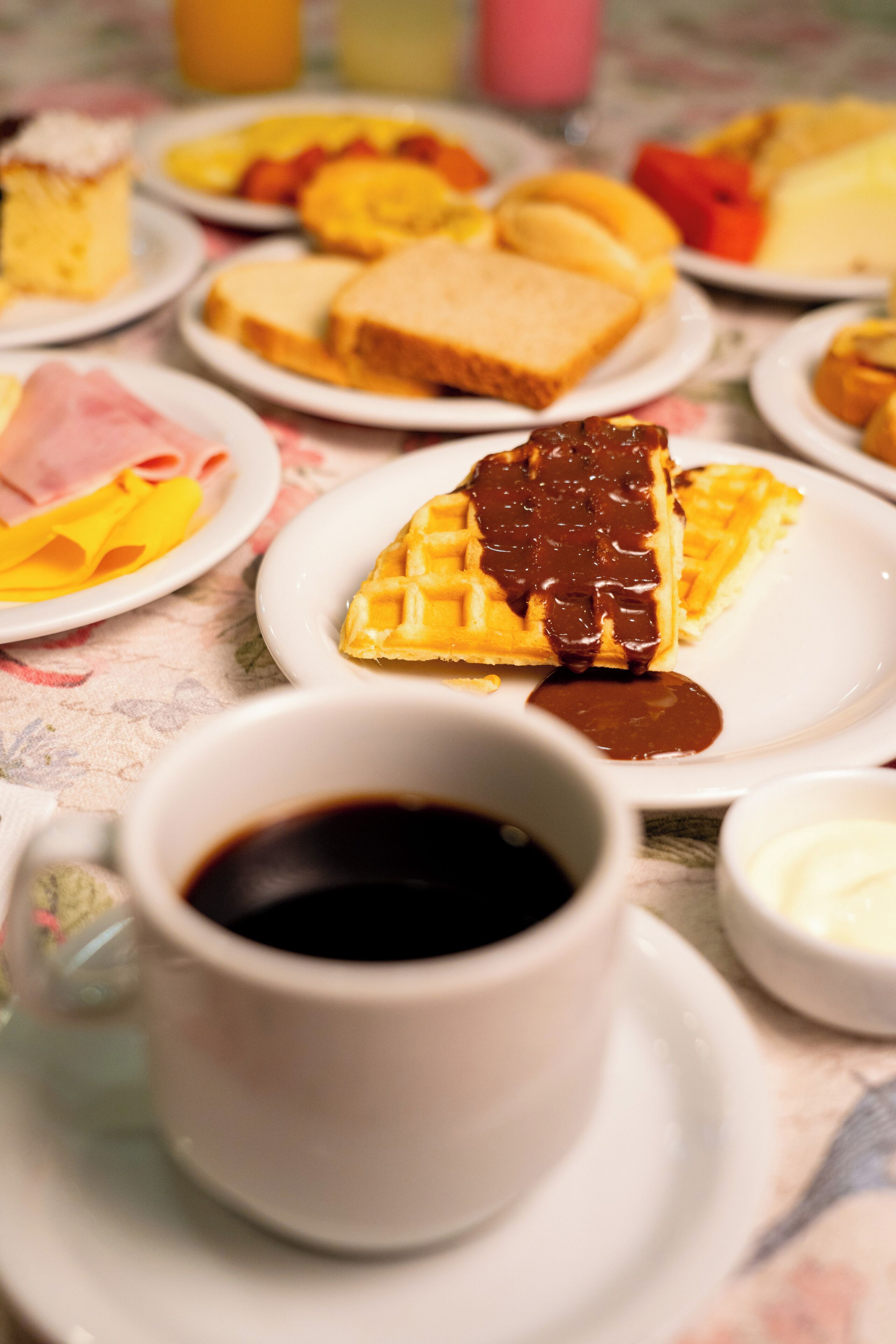 Een ontbijttafel met wafels, toast en een kop koffie.