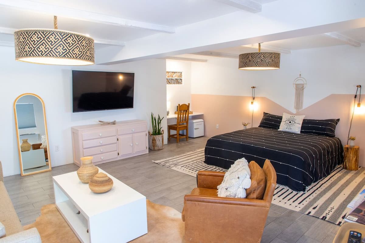 Une chambre moderne avec un grand lit, une télévision, un bureau et une chaise.