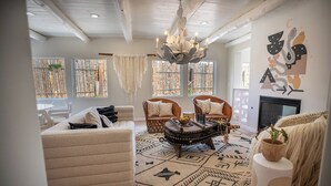 A living room with a sofa, chairs, a coffee table, and a chandelier. - The Mystic Santa Fe (Santa Fe)