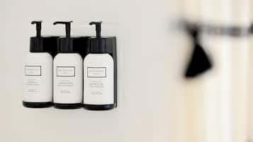 Three bottles of Beekman Fresh Air products: shampoo, conditioner, and shower gel, displayed on a wall.