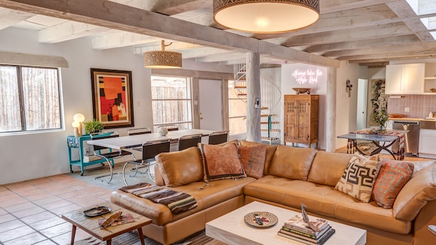 A spacious living room with a large L-shaped leather sofa, a coffee table, and a dining area with a table and chairs. - The Mystic Santa Fe (Santa Fe)