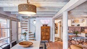 A spacious kitchen with a dining area, a staircase, and a neon sign. - The Mystic Santa Fe (Santa Fe)