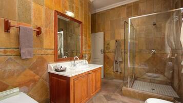 Un baño con ducha, lavamanos e inodoro.