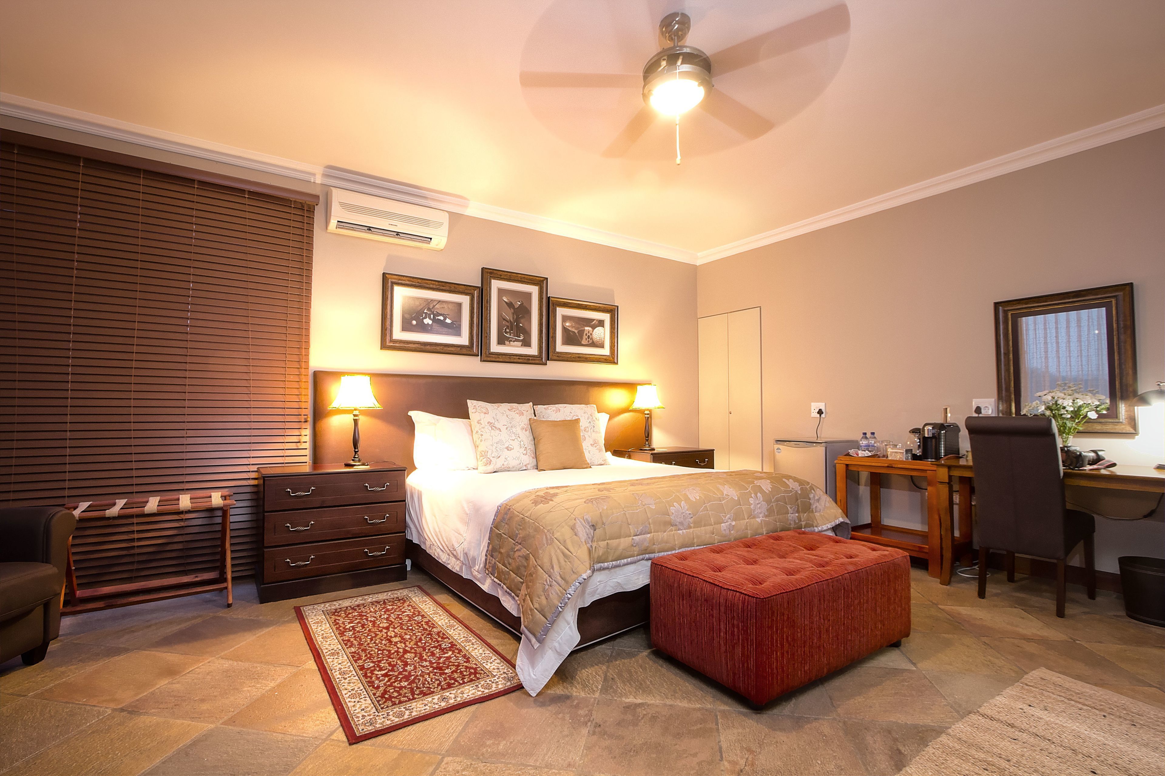 A bedroom with a bed, bedside tables, a desk, and a chair.