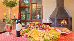 Una mesa con diversos alimentos, una botella de vino y un florero con flores.