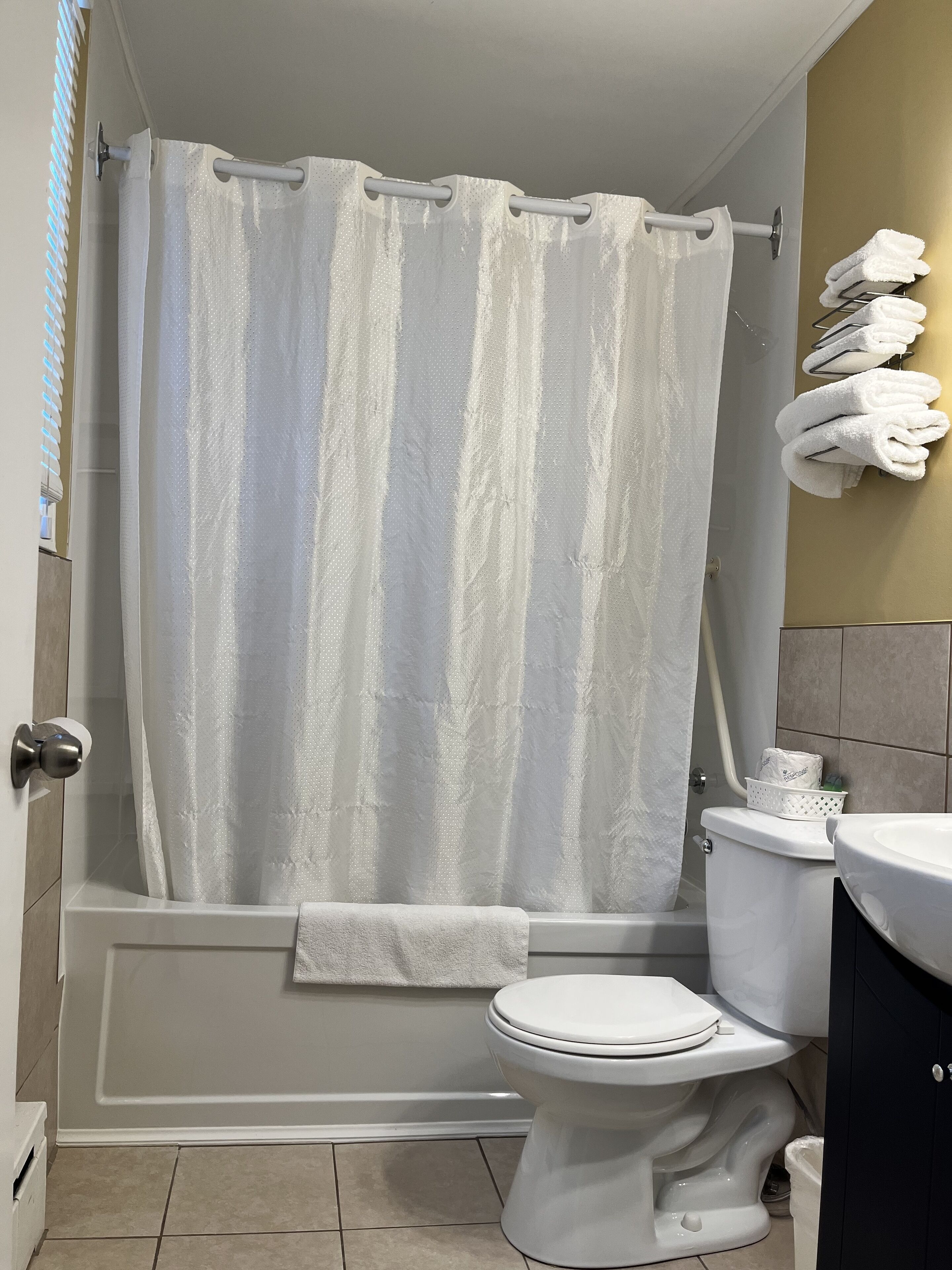 Un baño con bañera, inodoro y lavamanos.