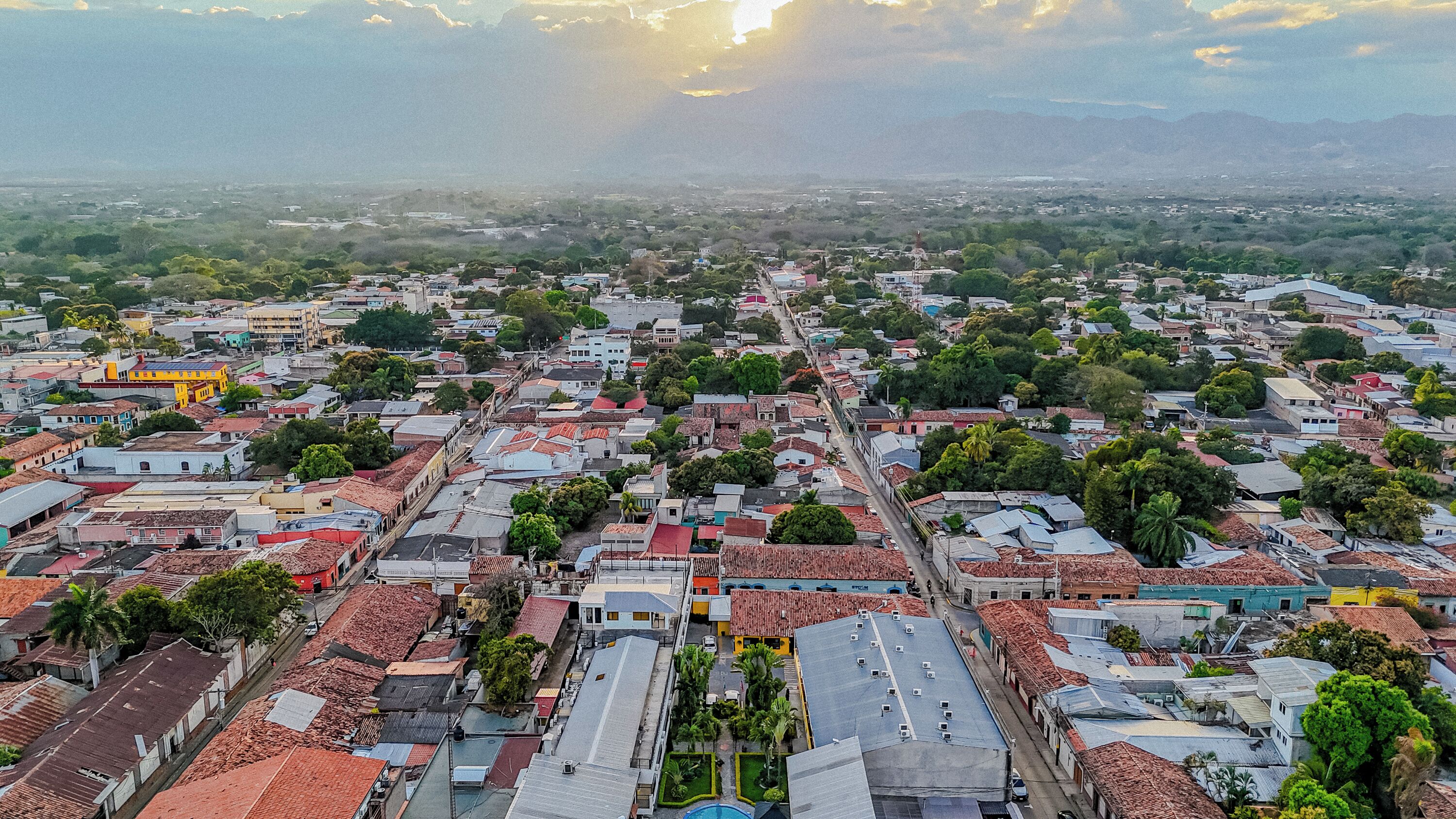 An aerial view of a densely packed urban area with buildings, roads, and greenery.