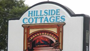 A sign for Hillside Cottages with a fireplace illustration. - Hillside Cottages (Missouri Valley)
