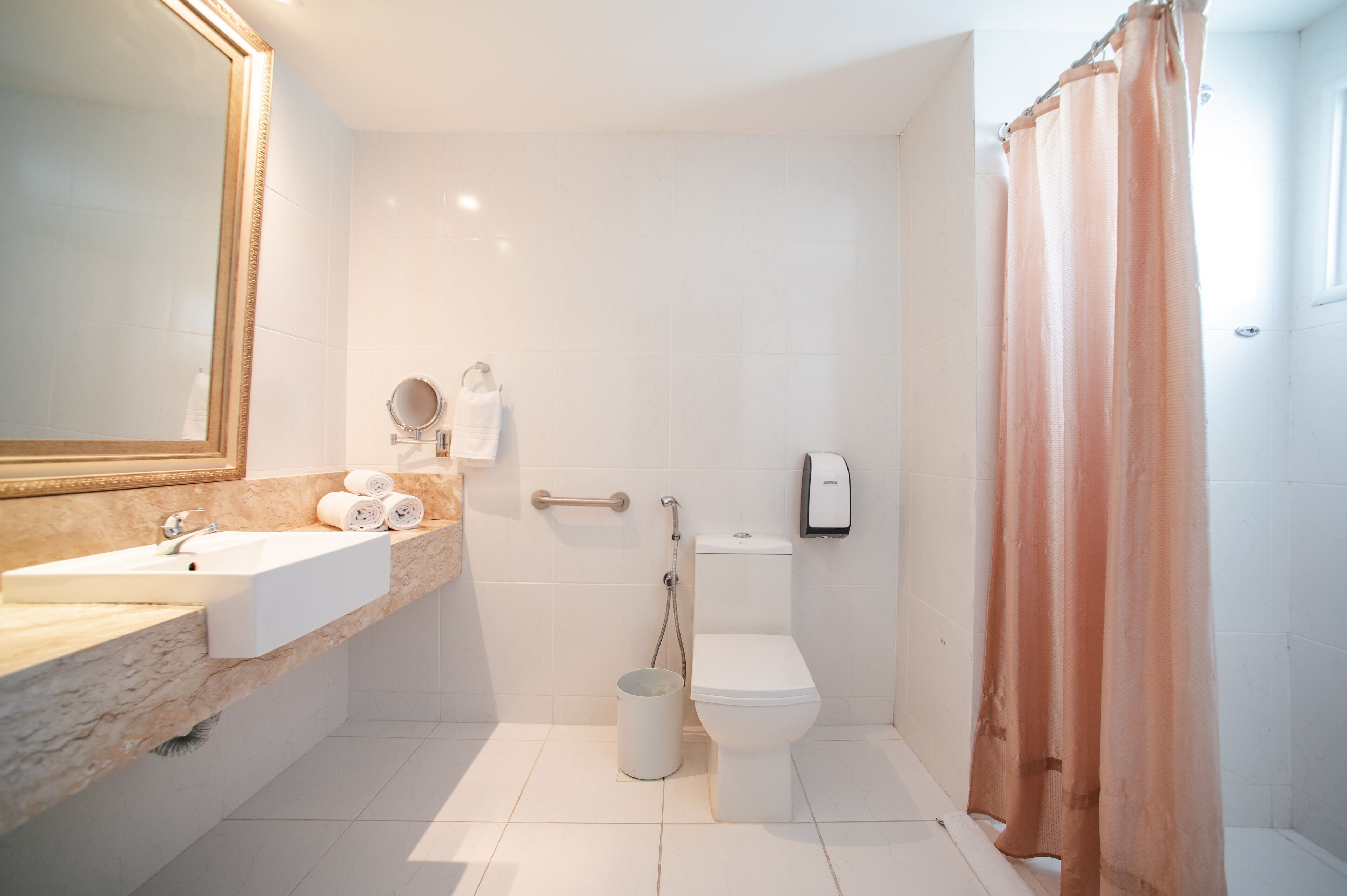 Een moderne badkamer met een wastafel, toilet en douche.