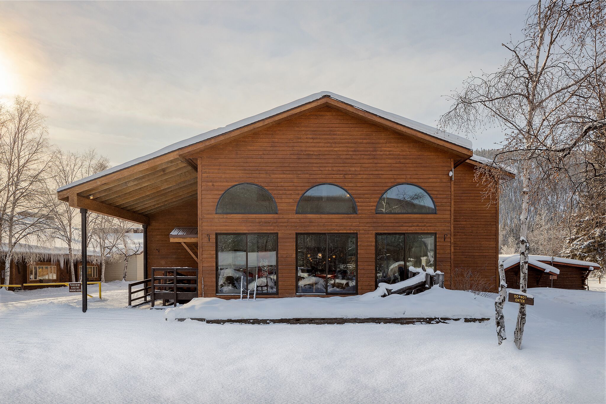 A wooden cabin with a covered porch and large windows.