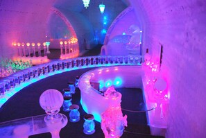 An ice bar with illuminated bottles and a large ice sculpture. - Chena Hot Springs Resort (Fairbanks)