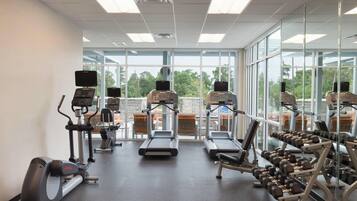 A gym with treadmills, an elliptical, and weight machines.