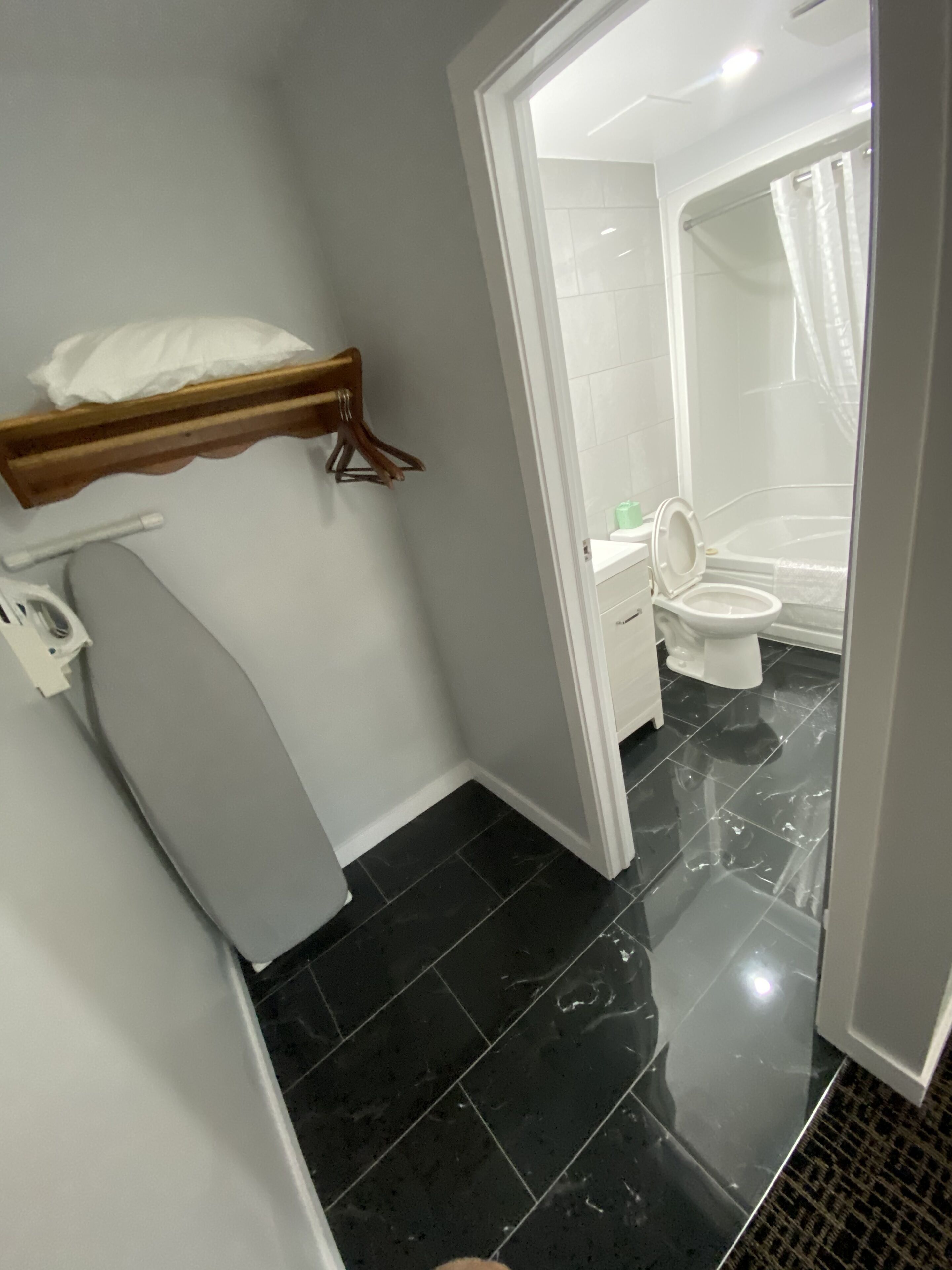 Ein Badezimmer mit Toilette, einer Duschkabine mit Glastür und einem Waschtisch mit Spiegel.