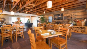 Ein Restaurant mit Holztischen, einer Uhr an der Wand und einem Schild mit der Aufschrift 'Sand's on Golden Lake'.