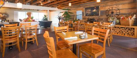 A restaurant with wooden furniture, a clock on the wall, and a sign that reads "Sand's on Golden Lake".